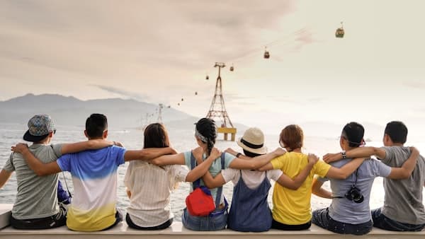 People sitting together looking at scenic mountain view, representing community connection and communication